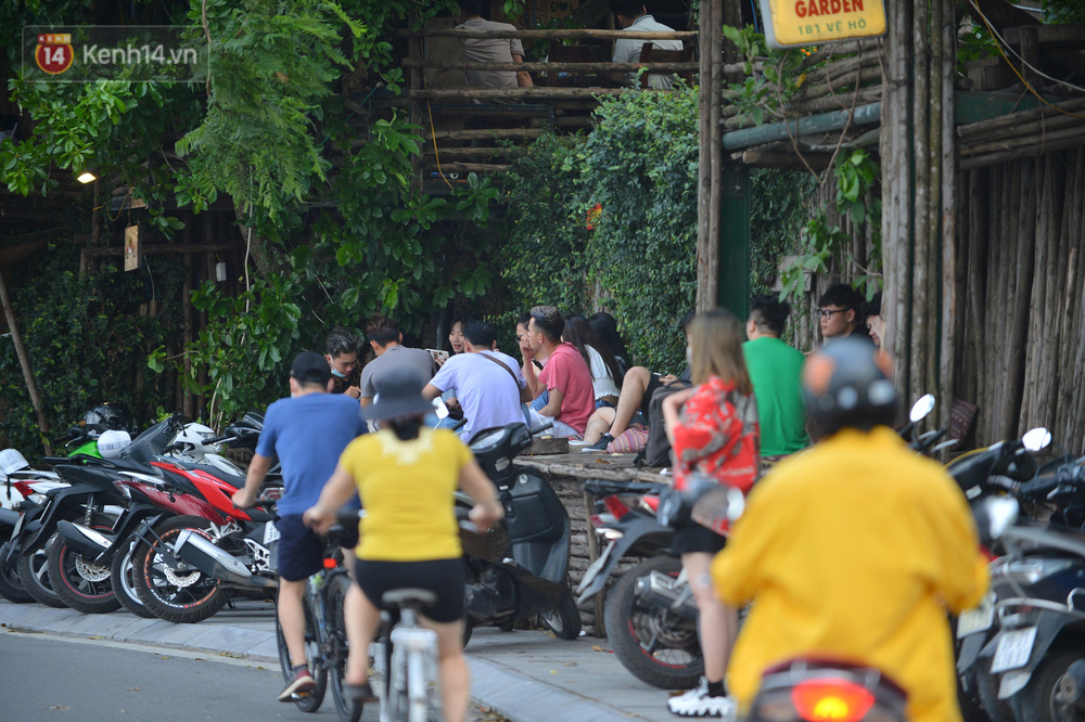 Một quán nước ven hồ Tây có hàng chục bạn trẻ ngồi tụ tập bên ngoài vỉa hè