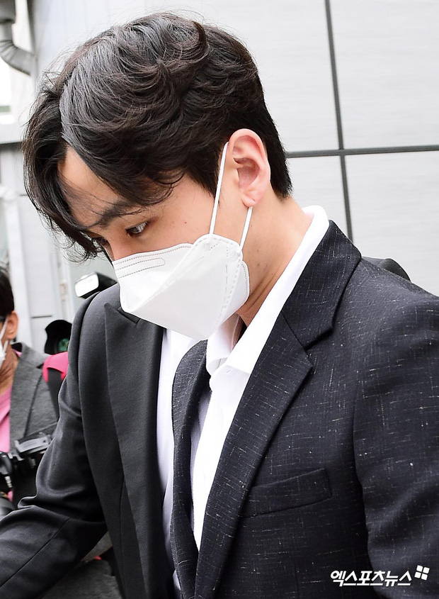 Nam idol cúi gằm mặt, tránh ống kính phóng viên trên đường đến tòa án