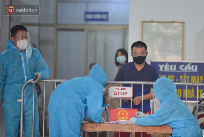 Cử tri được lực lượng chức năng mặc áo bảo hộ hướng dẫn bỏ phiếu