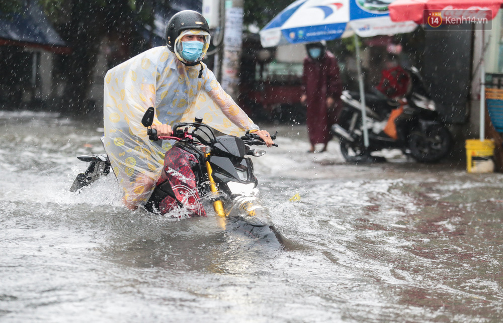 Thanh niên đi xe máy cố tăng hết ga để vượt điểm ngập lút bánh xe