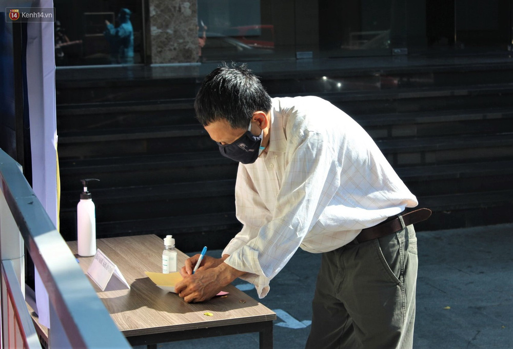 Bảng niêm yết ứng cử viên, bàn viết phiếu bầu, có bút, thước kẻ đặt trong hàng rào