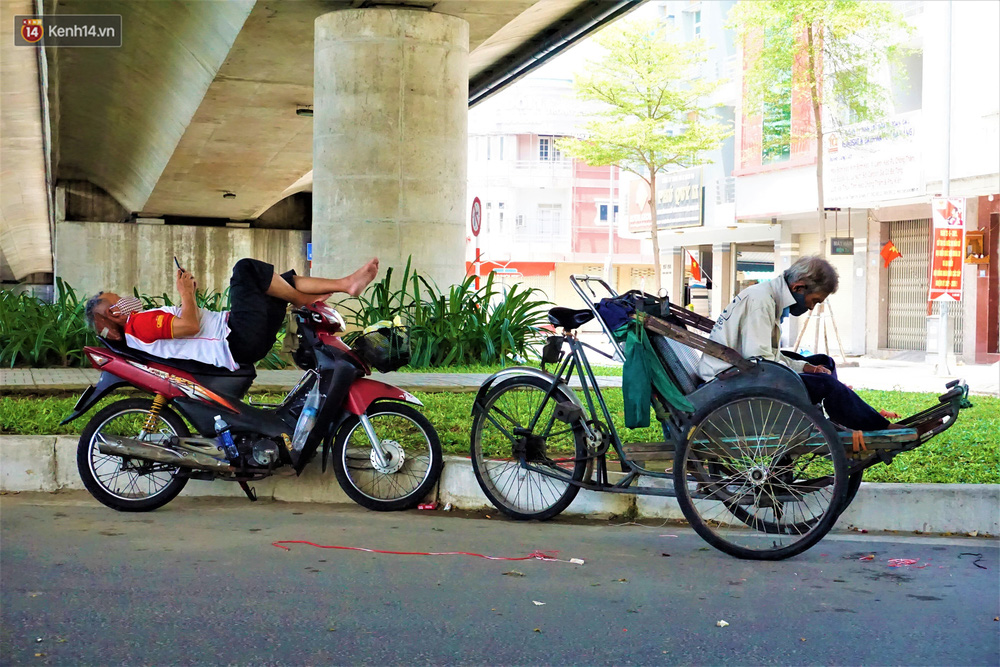 Nhiệt độ ngoài trời ở Đà Nẵng những ngày này nhiều nơi vượt ngưỡng 40 độ C. Vỉa hè, lề đường lại càng nóng hơn vì khói bụi xe cộ và khí nóng bốc lên từ mặt đường, thế nhưng vì tính chất công việc cũng như điều kiện kinh tế khó khăn mà nhiều người vẫn chọn nơi đây làm chỗ nghỉ ngơi ngay giữa buổi trưa nắng gắt. Gương mặt ai cũng mệt mỏi vì oi bức, vì những gánh nặng mưu sinh