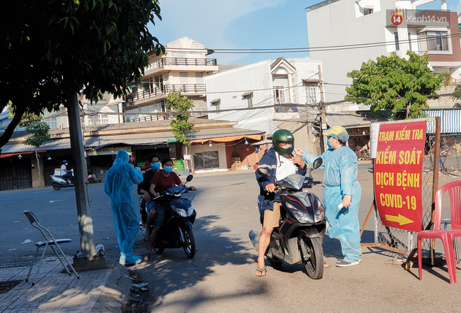 Lực lượng chức năng lập chốt kiểm tra y tế đối với những tiểu thương, tài xế và người dân ra vào chợ đầu mối Hóc Môn