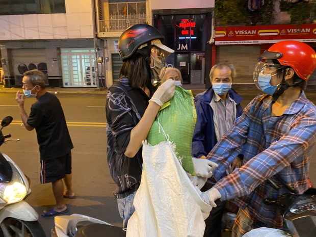Cô tự tay trao những bao gạo cho người nghèo, người vô gia cư