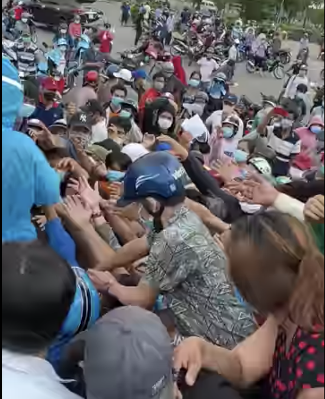 Hình ảnh rất đông người dân bao vậy 2 nhân viên y tế, chen nhau lấy giấy xét nghiệm tại chợ Bình Điền (ảnh cắt từ clip)