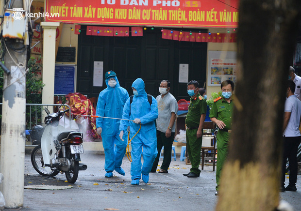 Nhân viên y tế phun khử khuẩn khu vực nhà F0 tại phường Nghĩa Đô, quận Cầu Giấy (Ảnh: Đinh Huy)