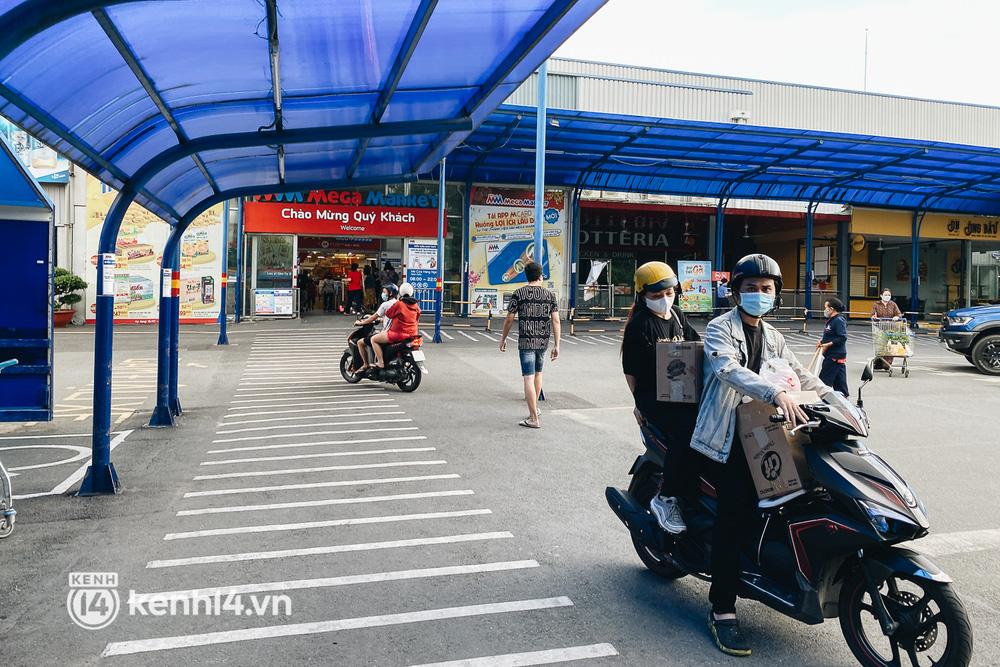 Hai bạn trẻ mua hai thùng thực phẩm thiết yếu rời siêu thị trước 