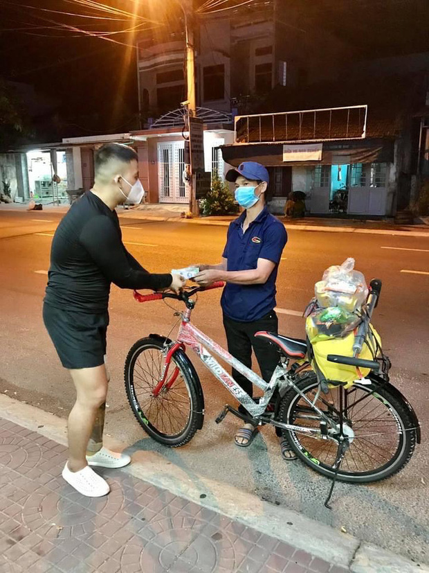Chàng trai khuyết tật Nguyễn Văn Lưu (bìa trái) trao quà hỗ trợ cho anh Phạm Văn Dũng trước khi anh lên đường tiếp tục về quê