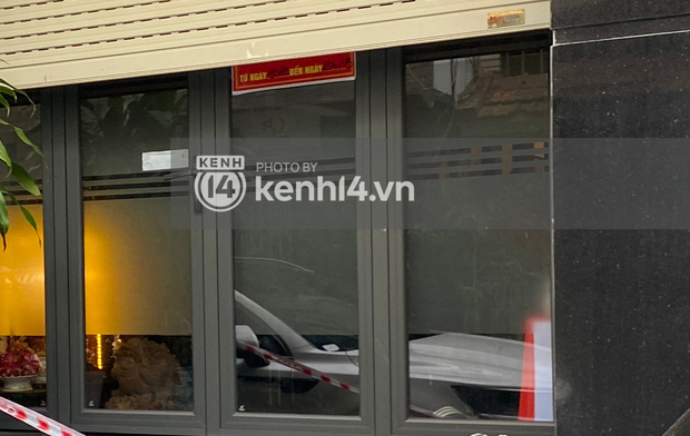 Biển cảnh báo nền đỏ trước cửa nhà ca sĩ A bị cửa cuốn che mất một nửa