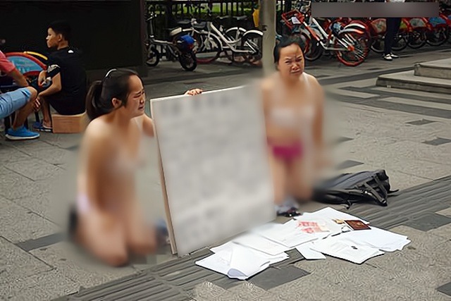 Hai người phụ nữ bán khỏa thân, quỳ trên phố xin tiền, lý do phía sau gây bất ngờ - 1