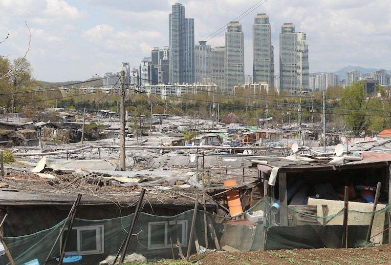 Giữa Seoul hoa lệ, đối lập với những toà chung cư sang trọng, sáng đèn là những căn nhà lụp xụp ở làng Guryong (Ảnh: Reuters)