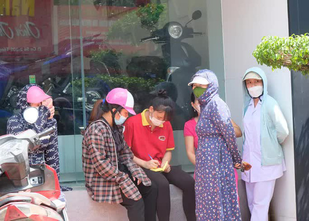 Tuy nhiên, phía đối diện tiệm bánh bên kia đường, nhiều người dân vẫn túm tụm đăng ký mua bánh