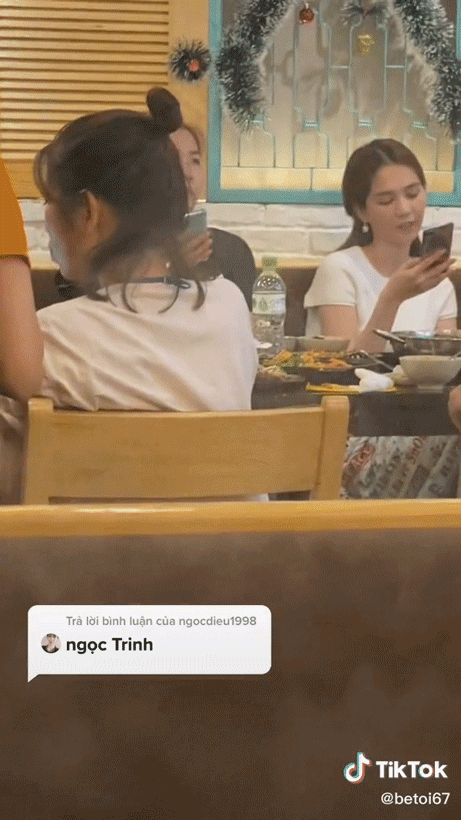 Ngọc Trinh ngồi nghịch điện thoại khi đi ăn cùng bạn bè