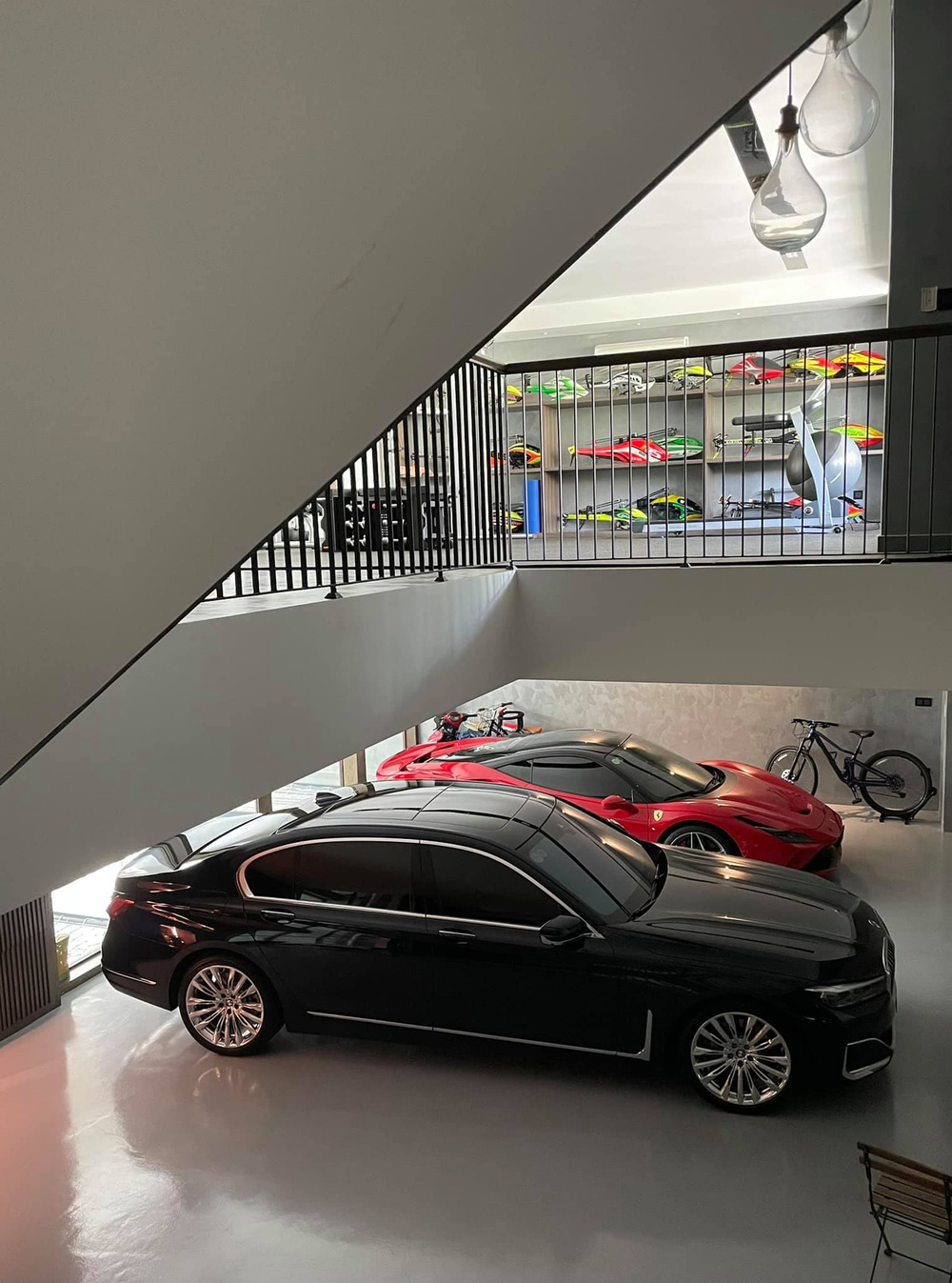 Phần cầu thang của căn biệt thực được thiết kết độc đáo, nhìn được gara ở tầng hầm và phòng tập thể dục ở tầng trên.
