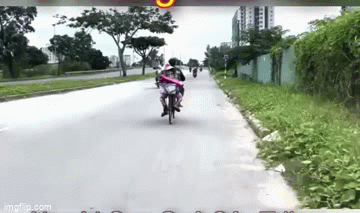 Đôi vợ chồng đèo bồng nhau trên chiếc xe đạp