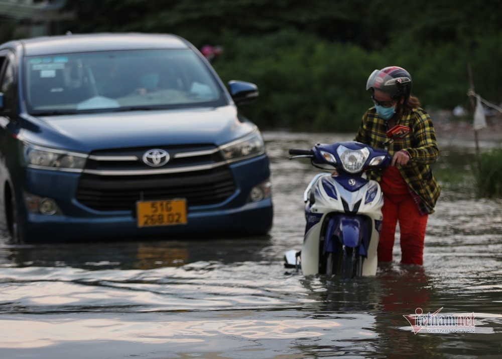 Bà Mỹ di chuyển qua đường Lương Định Của để về nhà sau khi tan giờ làm tại công trình. Khi đến đoạn đường ngập, xe chết máy phải dắt bộ. 