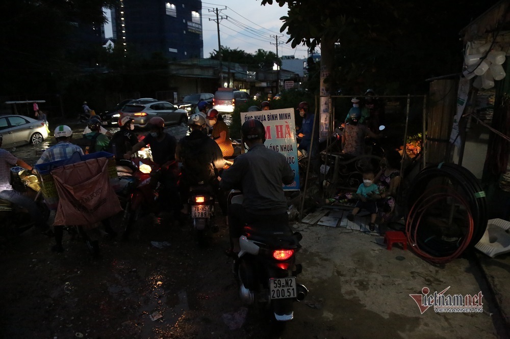 Nước dâng cao gây ngập đường khiến các phương tiện di chuyển khó khăn hơn