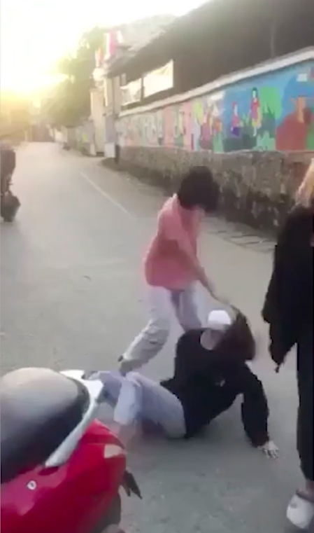 Nữ sinh chỉ biết ngồi chịu đòn.