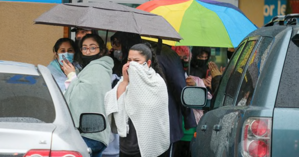 Khách mua sắm đứng bên ngoài cửa hàng nơi diễn ra vụ nổ súng ngày 23-12. Ảnh: AP