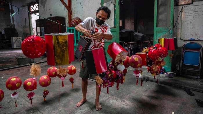 Người đàn ông ở Surabaya, Indonesia làm đèn lồng đón Tết Nguyên đán 2022. Ảnh: AFP