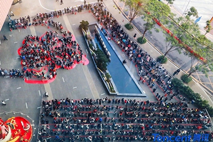 Vào ngày đi làm đầu tiên của năm mới, các nhân viên nối đuôi nhau chờ được lì xì bên ngoài trụ sở của Tencent ở thành phố Thâm Quyến, Trung Quốc. Ảnh: SCMP