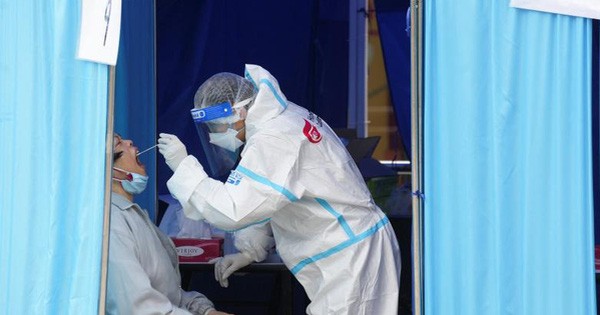 Nhân viên y tế lấy mẫu xét nghiệm Covid-19 cho một phụ nữ ở Hồng Kông ngày 18-2. Ảnh: Reuters