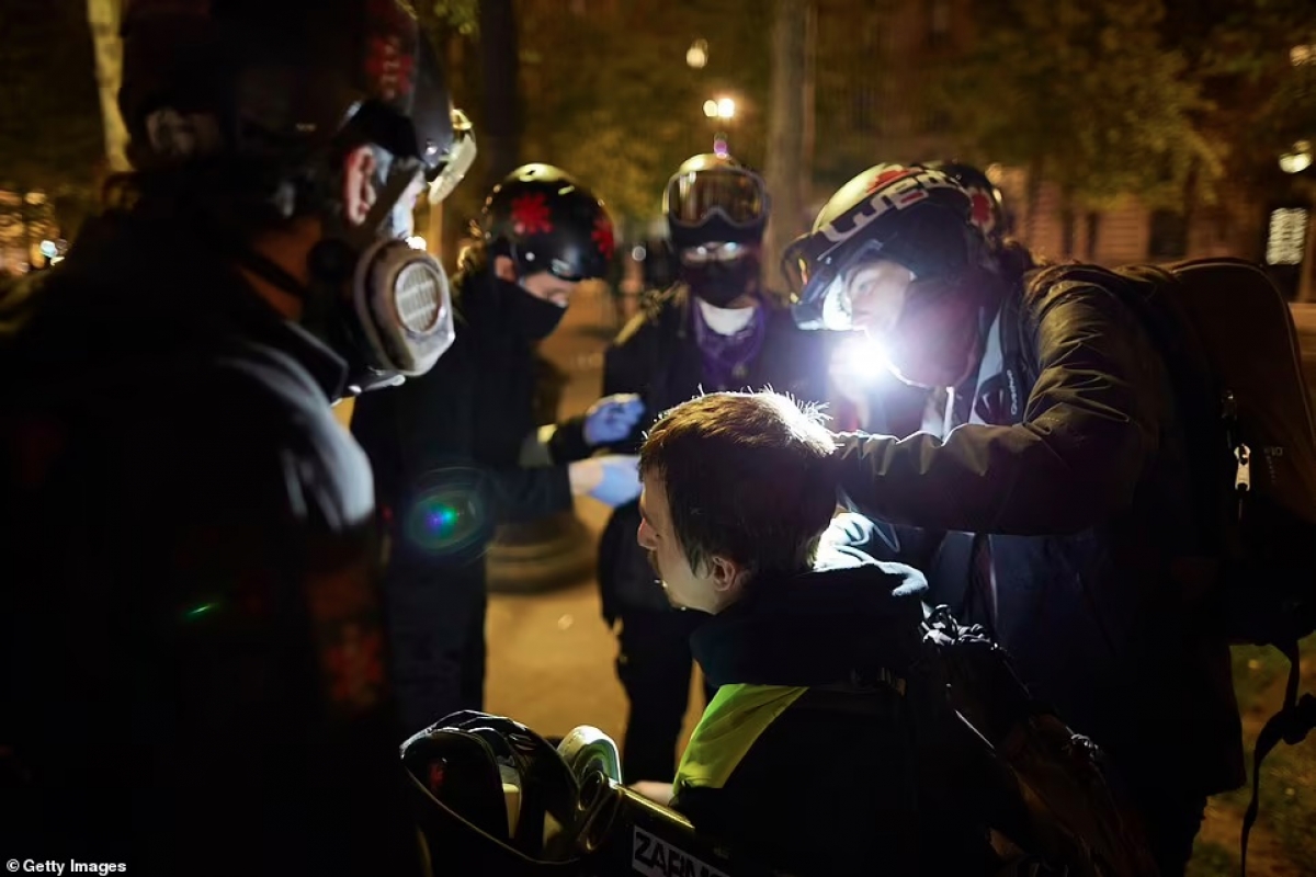 Sơ cứu cho một người biểu tình bị thương sau khi đụng độ với cảnh sát Pháp ở trung tâm Paris vào tối 24/4. Ảnh: Getty.