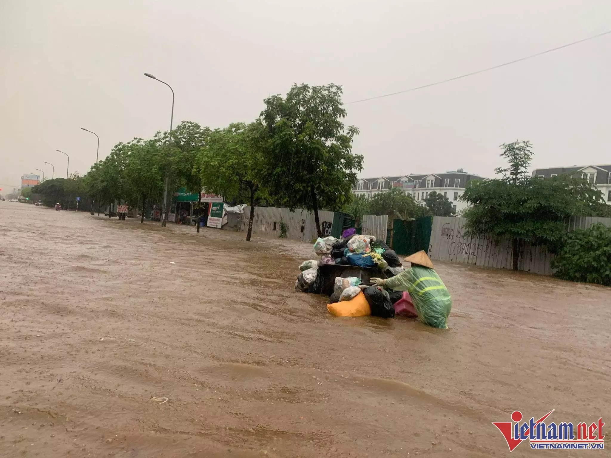 Công nhân đẩy xe rác trong 