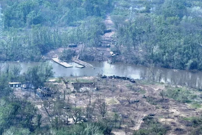 Ảnh chụp từ trên không cho thấy các xe quân sự Nga bị cháy gần một cầu dựng tạm qua sông Siverskyi Donets bị phá hủy ở miền đông Ukraine ngày 12/5. Ảnh: Reuters