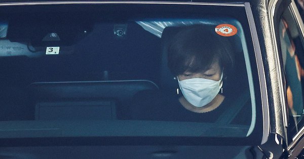 Bà Abe Akie ngồi ở ghế trước của chiếc xe tang, dường như chảy nước mắt. Ảnh: Reuters