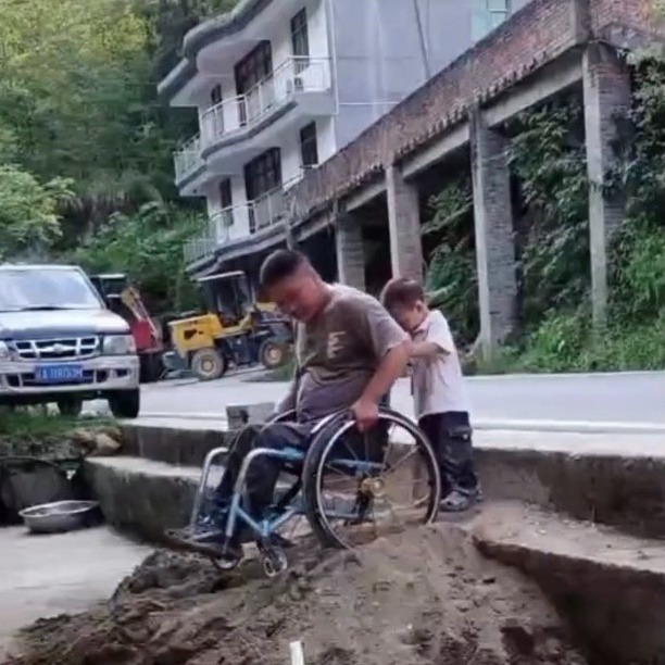  Cậu con trai gần 3 tuổi quá nhỏ bé bên bố và chiếc xe lăn. (Ảnh: Chụp màn hình Douyin) 