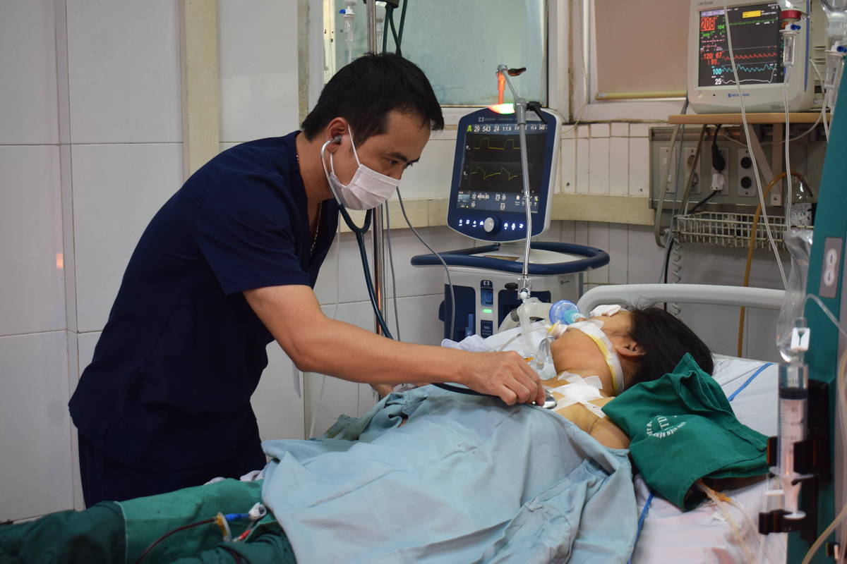 TS Thân Mạnh Hùng khám cho nữ bệnh nhân 38 tuổi bị sốt xuất huyết nặng đang điều trị tại khoa Cấp cứu. Ảnh: L.C