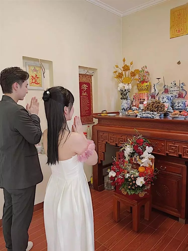 Cặp đôi làm lễ trước bàn thờ gia tiên.