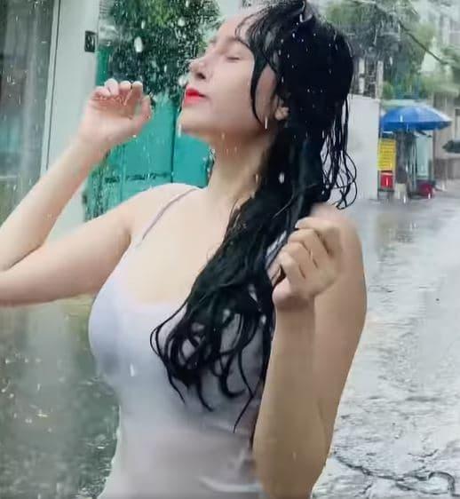 Trong đoạn video, hot girl bà Tưng mặc trang phục mỏng manh, thích thú khi tắm mưa. Cô viết: 