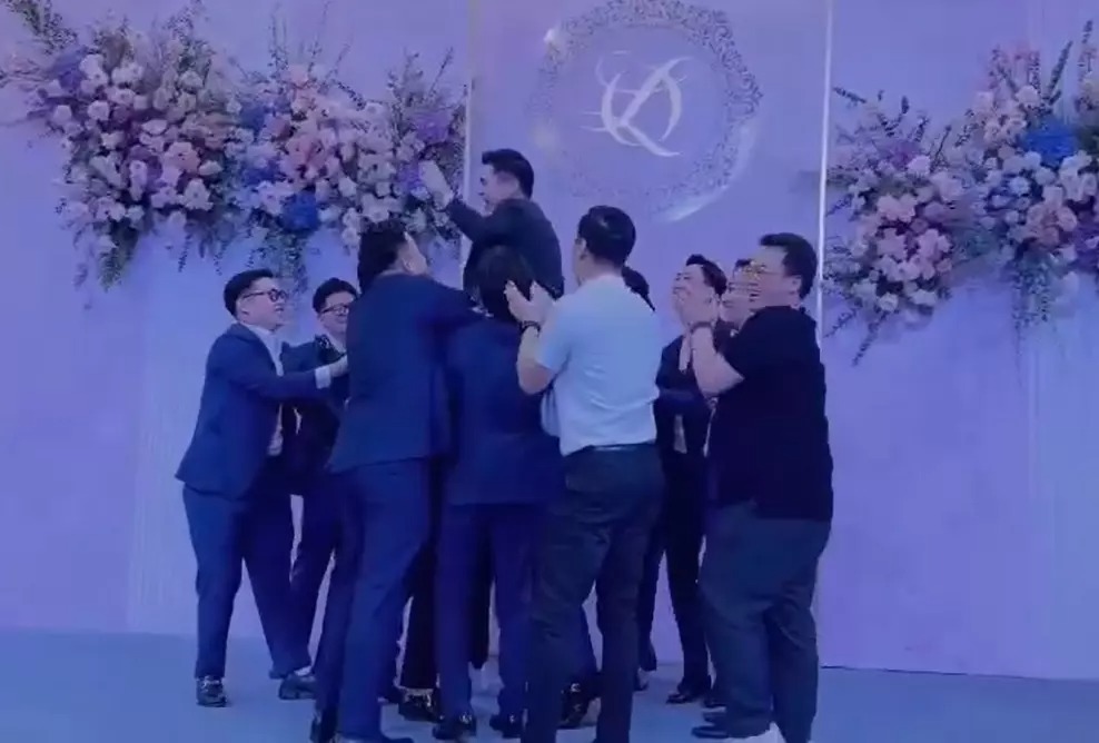 Chú rể Đỗ Vinh Quang liên tục bị đám đông tung lên cao.