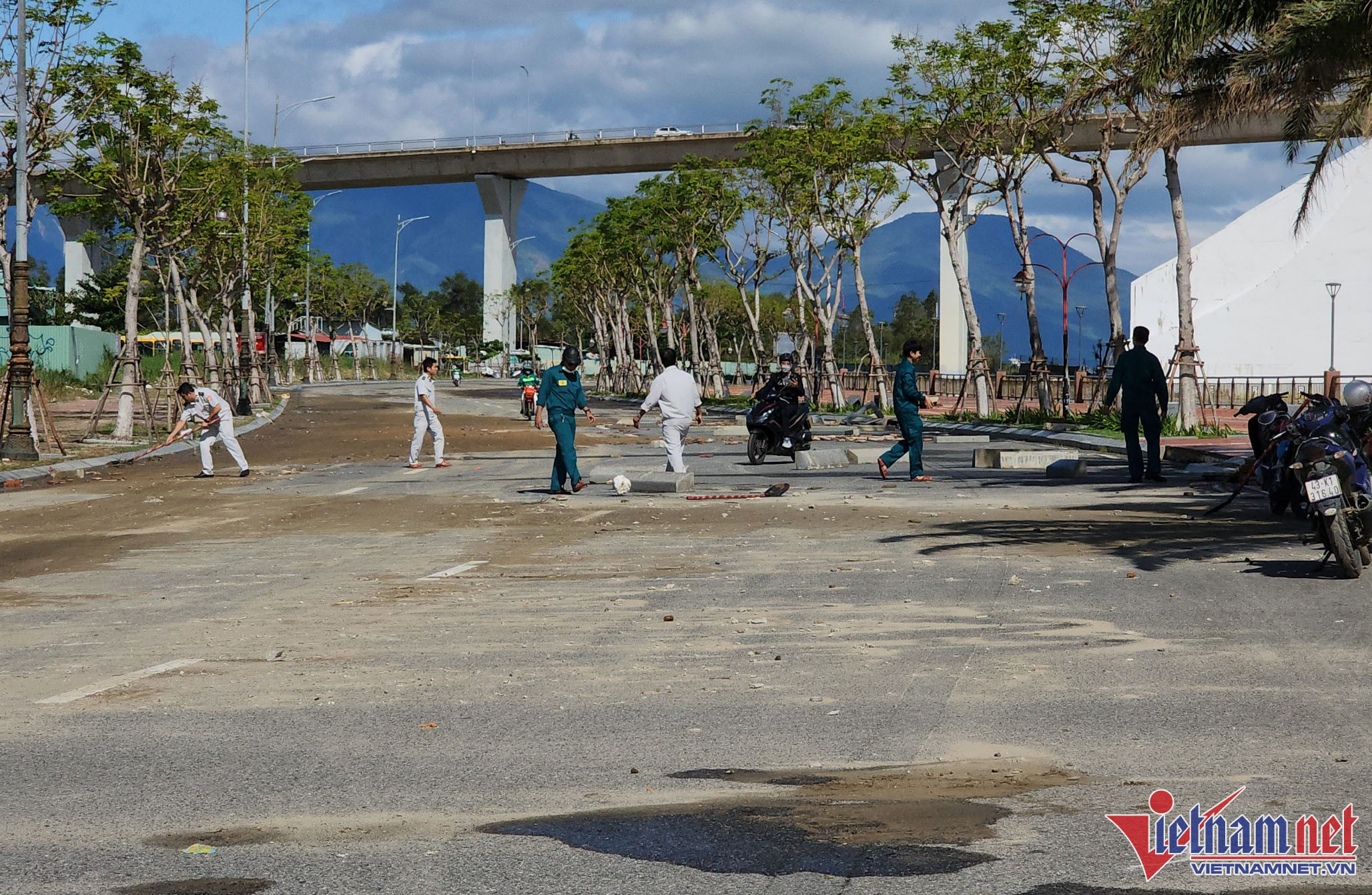 Lực lượng chức năng được huy động dọn dẹp gạch đá bị sóng đánh xuống mặt đường Như Nguyệt