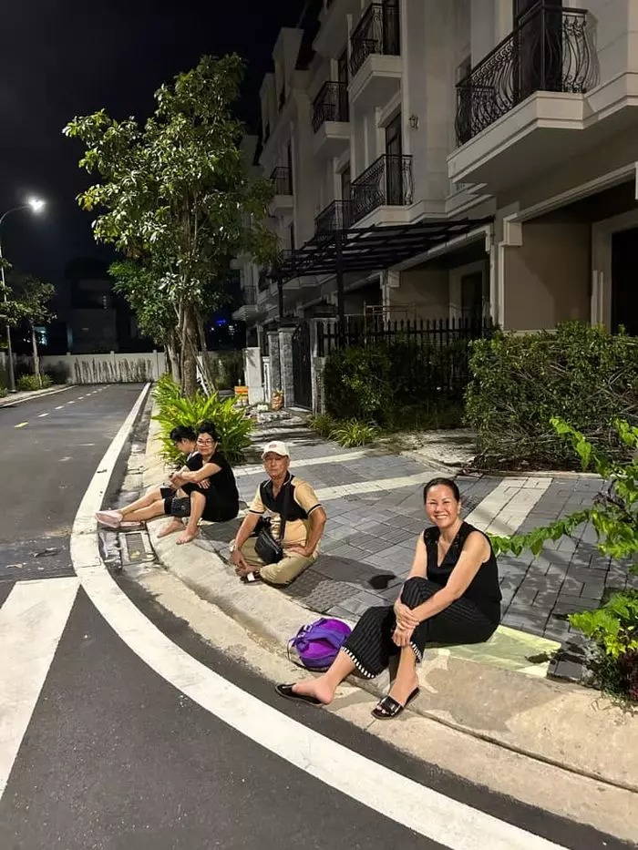 Người thân Di Băng ngồi ngoài đường ngắm nhìn căn nhà đang hoàn thiện.