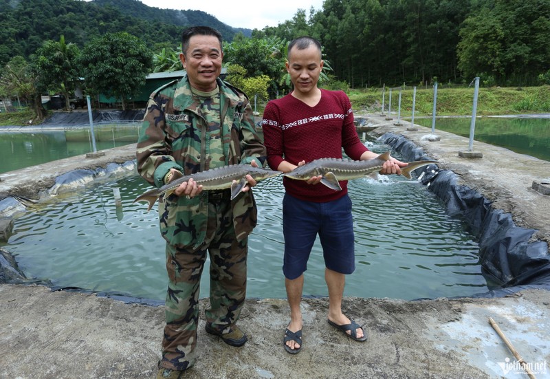 Ông Tân (bên trái) và con trai cầm trên tay cá tầm nặng khoảng 2kg