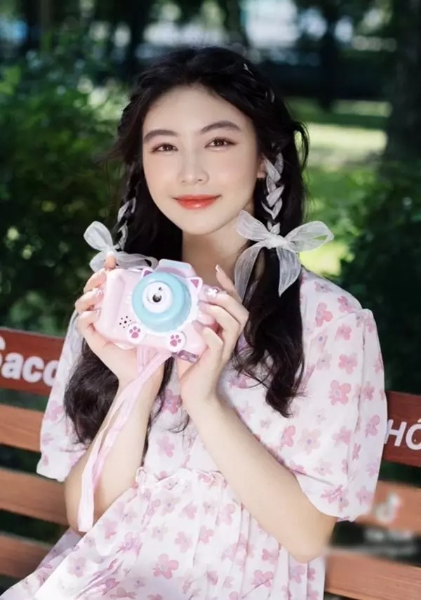 Phụ kiện đi kèm để hoàn thành bộ hình là chiếc máy ảnh cùng màu với trang phục.