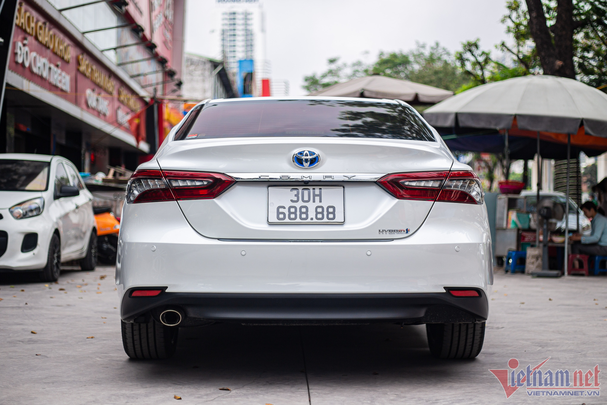 Logo Toyota màu xanh và tem chữ cho thấy chiếc xe là phiên bản động cơ xăng kết hợp điện.