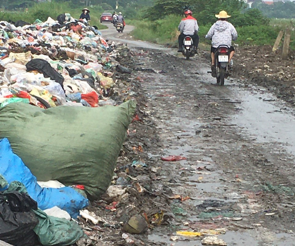 Rác thải tràn xuống lòng đường, nước rỉ rác không được thu gom chảy lên láng trên mặt đường liên xã