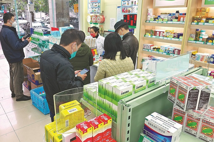 Người dân Trùng Khánh, Trung Quốc đi mua thuốc hôm 10/12. Ảnh: China Daily 