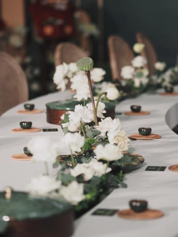 Điểm nhấn của không gian lễ ăn hỏi là bộ bàn ghế uốn lượn, được cách điệu từ hình ảnh dòng suối nhỏ thanh mát. Trên bàn, hoa sen, hoa hồng, hoa tường vi... với tông trắng được sắp xếp ở giữa bàn, tạo nên dòng suối hoa thơ mộng.