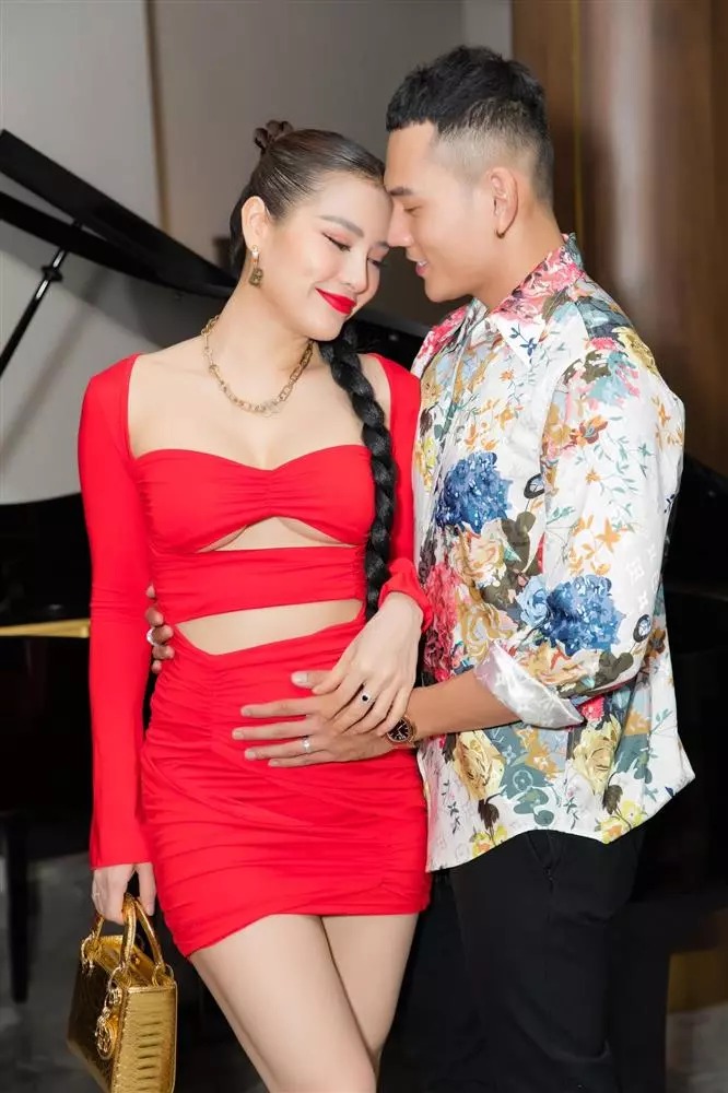 Bà bầu lựa chọn thiết kế đỏ rực với những đường cut-out khá táo bạo, khoe cả vòng 1 lẫn vòng eo. 