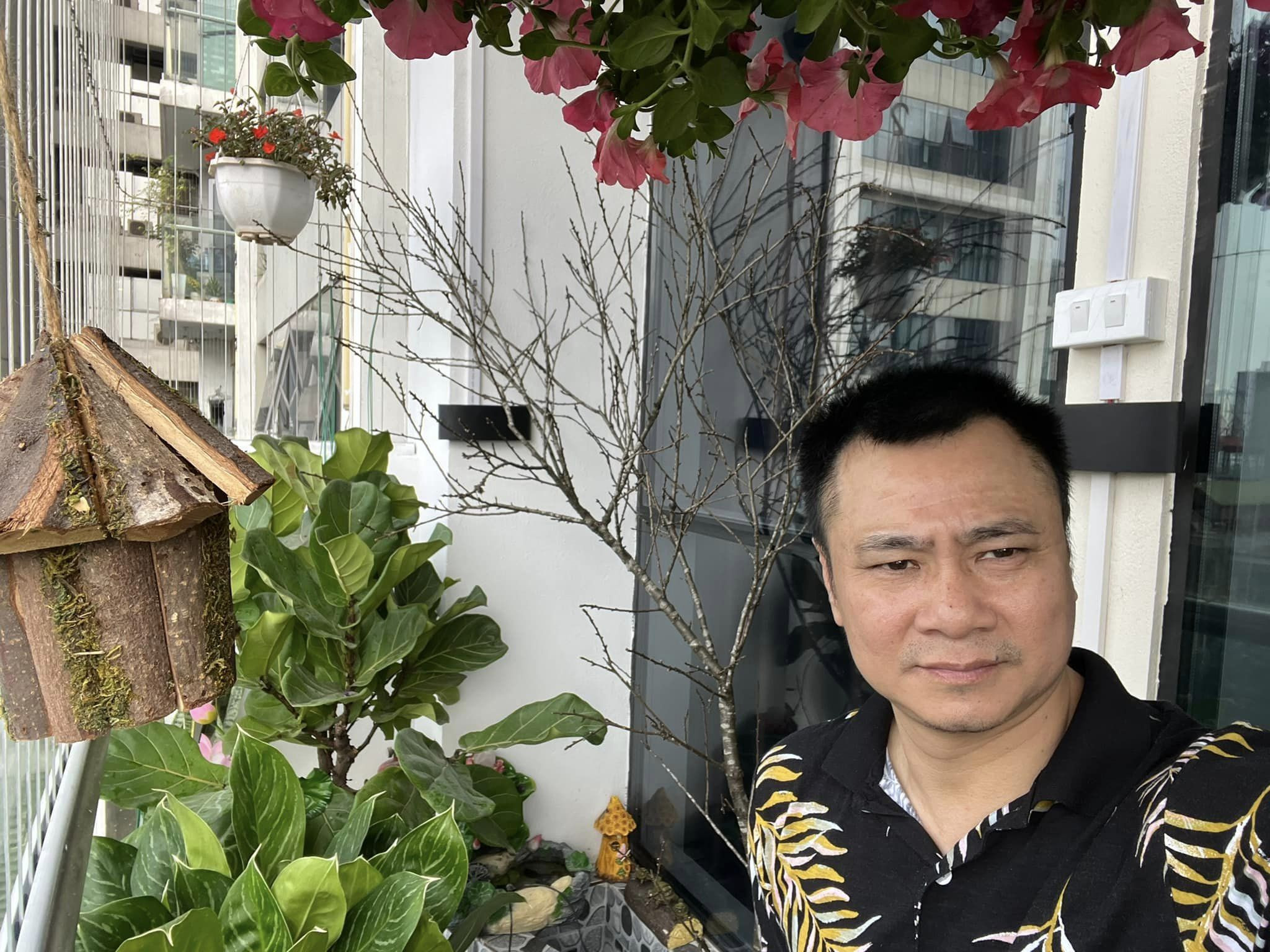 NSND Tự Long chuyển nhà mới dịp cận Tết. Căn hộ rộng rãi, hiện đại, có nhiều mảng xanh. Tự Long chuẩn bị các chậu đào đẹp, thêm không khí xuân cho ngôi nhà. 