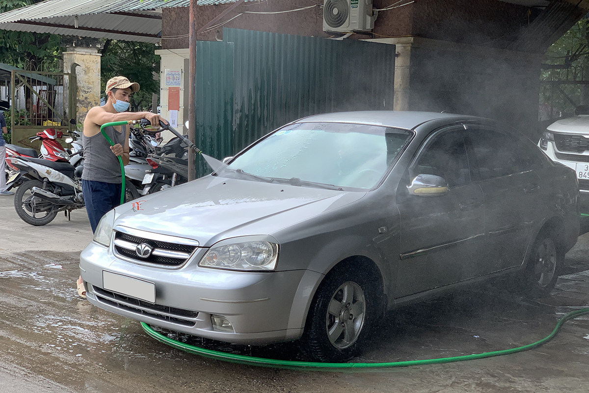 Nhân viên tiệm rửa xe tại quận Hà Đông luôn tay luôn chân. (Ảnh: Hoàng Hiệp)