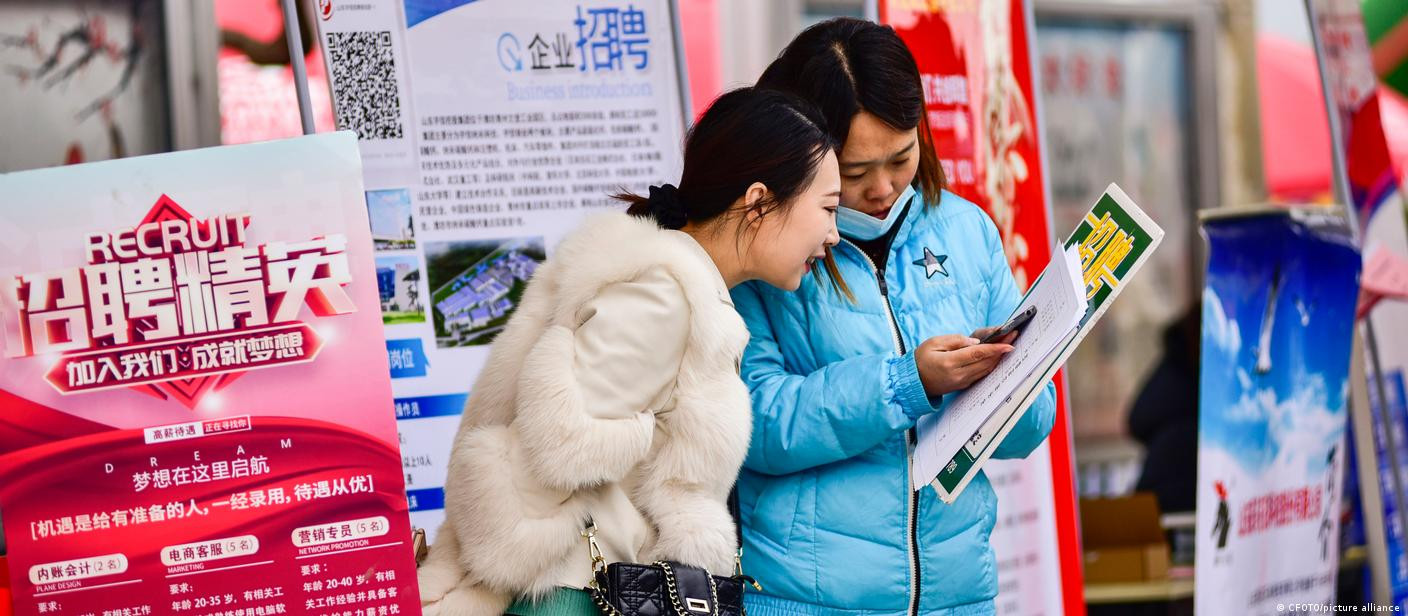 Cô gái đang tìm hiểu thông tin tuyển dụng. Ảnh: DW