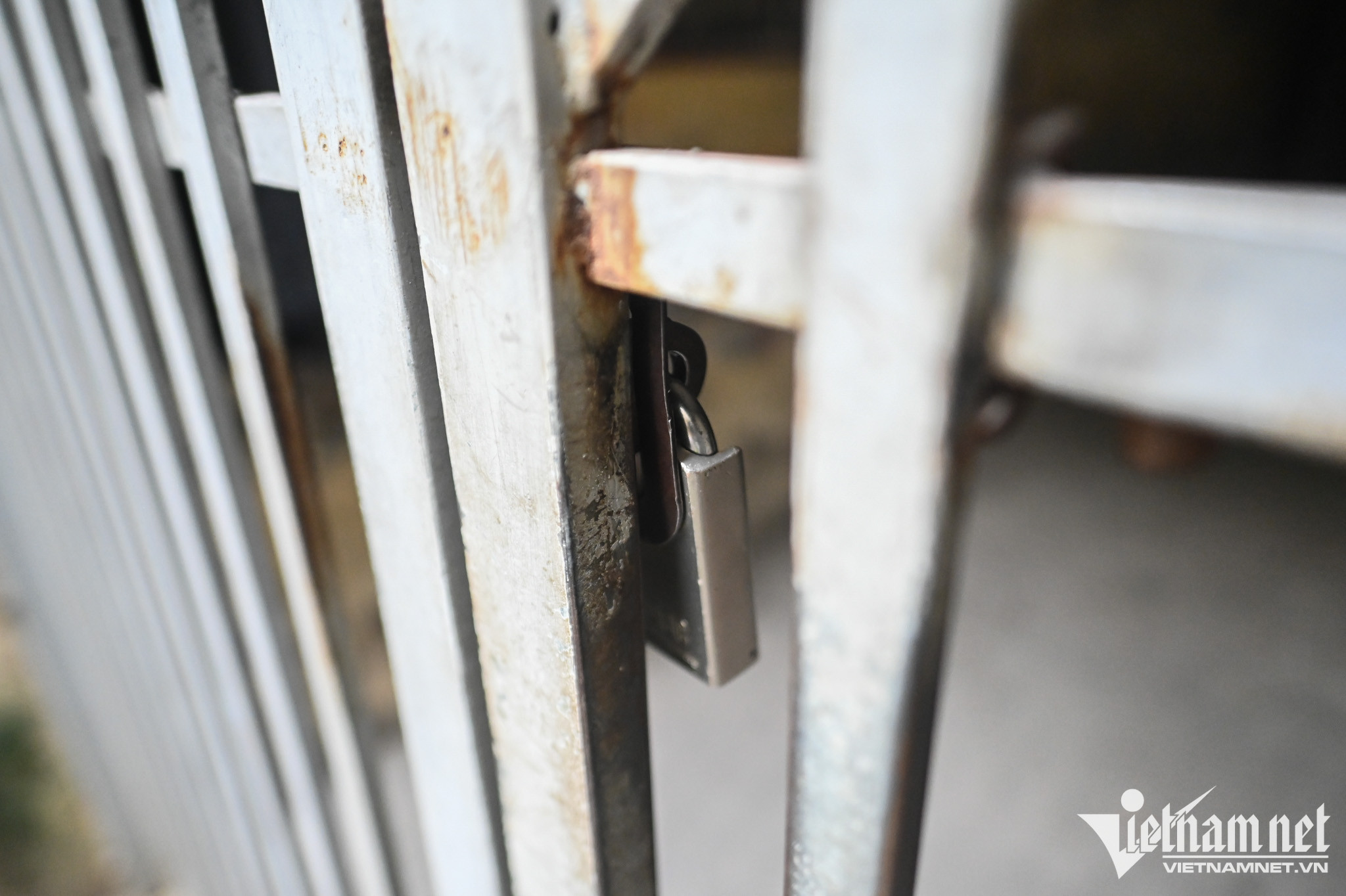 Lối cổng chính đi vào khu tập thể luôn trong tình trạng đóng cửa. Phía dưới, một vài hộ dân vẫn kinh doanh quán trà đá.