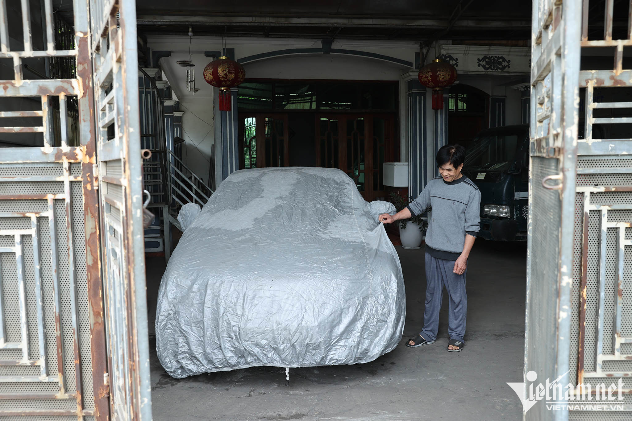 Chiếc ô tô của gia đình ông Trương Văn Thanh dù để trong nhà vẫn luôn phải phủ bạt tránh bụi. Ông cho biết, nếu không phủ bạt, chỉ từ sáng đến chiều là chiếc xe phủ trắng bụi. Ảnh: Lê Anh Dũng