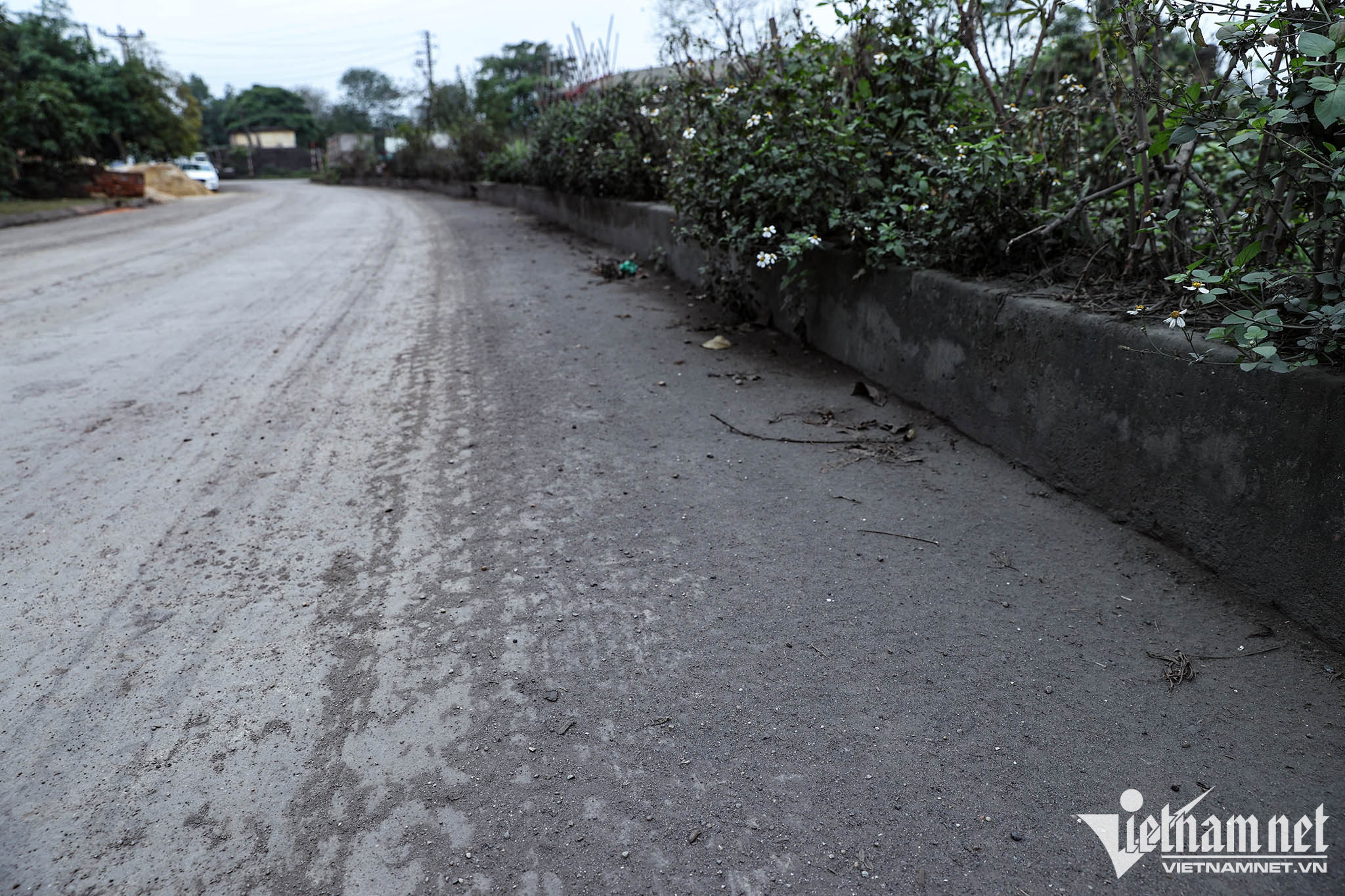 Mặt đường không chỉ lúc nào cũng phủ lớp bụi dày mà nhiều khi còn vương vãi bụi màu vàng mà theo ông Thanh và bà con đó là lưu huỳnh do mùi đặc trưng của loại hóa chất này bốc lên nồng nặc khiến rất khó thở. Ảnh: Lê Anh Dũng 